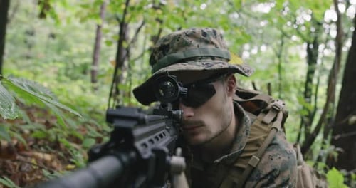 Soldier Aims Rifle in Dense Forest