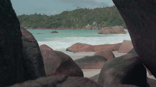 Seychelles. Praslin Island. Clean Waves Roll on the Sandy Beach and Large Stones Lying on the Sand