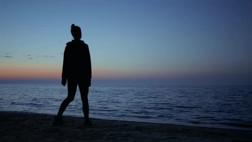 Silhouette Exercises on Beach at Colorful Sunrise
