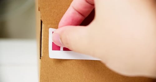 Applying a 'Made in Denmark' Sticker to Box