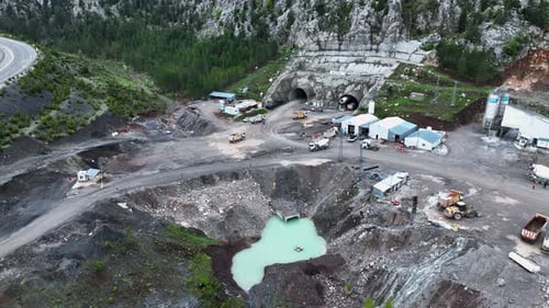 Heavy machinery drills tunnel through the mountain aerial view 4 K