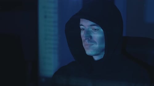 Hacker working on computer at night