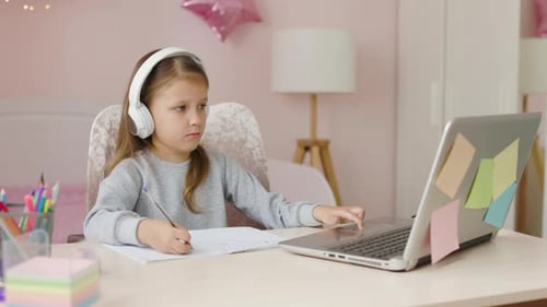 Girl with Headphones Uses Laptop for Studying