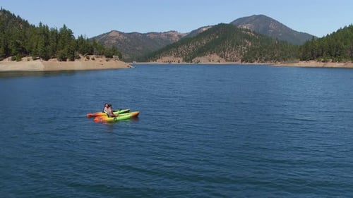 Aerial drone shot of couple kayaking on lake