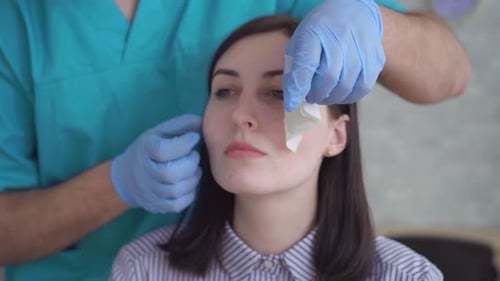 Woman Having Bandage Removed at the Medical Clinic