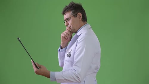 Mature Handsome Man Doctor Against Green Background
