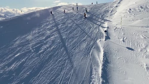 People skiing on snowy slope at ski resort in the mountains