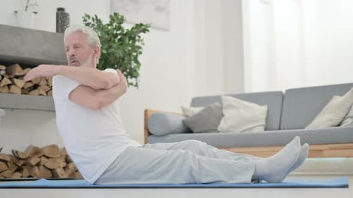 Senior Man Stretching on Blue Mat Indoors