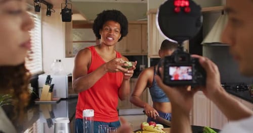 Grupo diverso de amigos haciendo videoblog culinario en cocina
