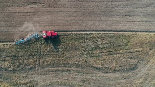 Countryside and Agriculture Grain Sowing Farm Tractors Plow the Earth in Field View From Height