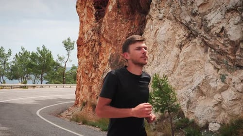 Jeune homme en tenue de sport faisant du jogging par une journée d'été ensoleillée.