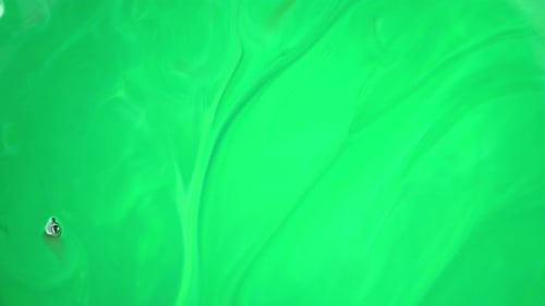 Footage. Ink in Water. Green Ink Reacting in Water Creating Abstract Background.