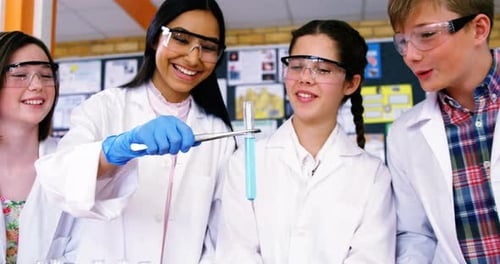 Smiling school kids doing a chemical experiment in laboratory