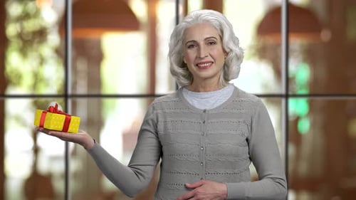 Elegant Senior Woman Holds Birthday Gift