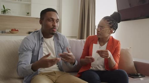 Couple Discuss Finances on Couch Together