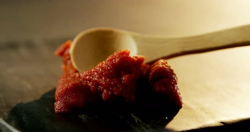 Chutney au piment rouge étalé sur une planche de béton 4k