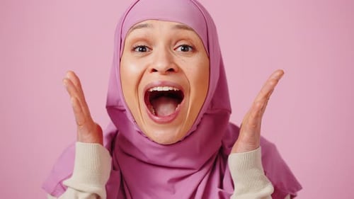 Surprised Woman Smiles and Gestures in Pink Studio