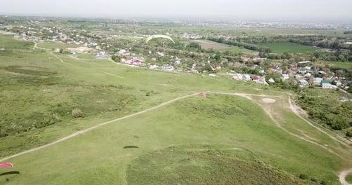 Paragliders Soaring Above Green Rural Countryside