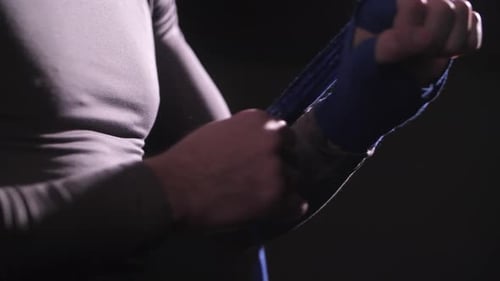 Man Wraps Hands with Blue Boxing Tape