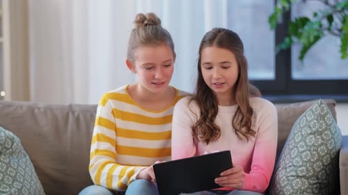 Teen Girls Using a Tablet on Sofa