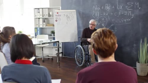 Professor in Wheelchair Lecturing to Students in Classroom