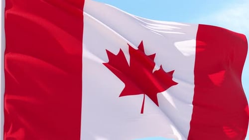 Waving Canadian Flag Against Blue Sky Background
