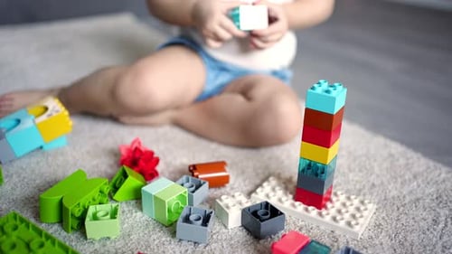 Kaukasisches Kind, ein kleines Mädchen, spielt zu Hause im Constructor