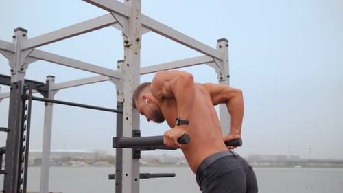 Muscular Man Doing Dips at Outdoor Gym