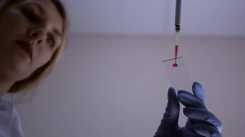 Scientist Pipetting Blood Sample on Slide for Analysis