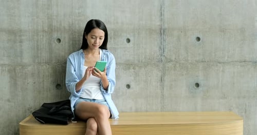 Woman Using Mobile Phone While Sitting on Bench
