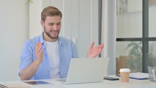 Young Adult Waving During Online Meeting