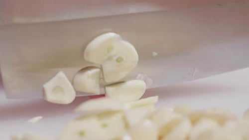 Slow motion close up woman hand knife slide garlic for prepare ingredient food