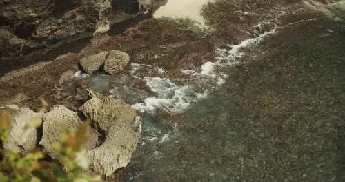 Nahaufnahme Zeitlupenansicht der Wellen, die am felsigen tropischen Strand krachen, Nahaufnahme des Schäumens