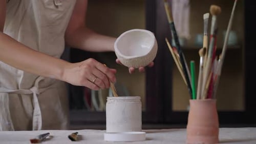 Artist Glazing Ceramic Bowl in Pottery Studio