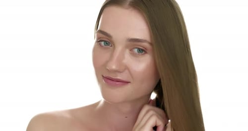 Attractive Woman Brushing Long Hair in Studio