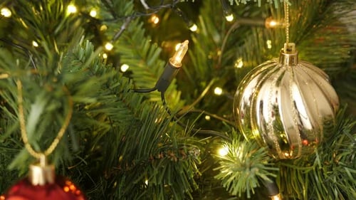 Close-up of shiny decorative golden bauble on the artificial tree 4K 2160p 30fps UltraHD footage -