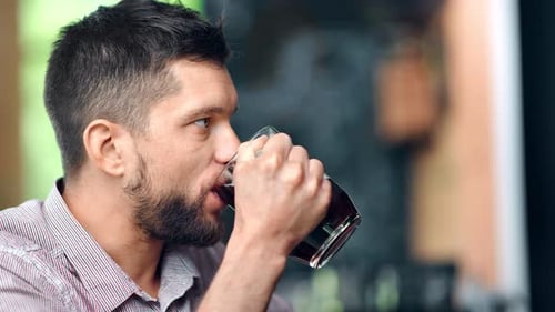 Man Drinking Refreshing Beverage Indoors