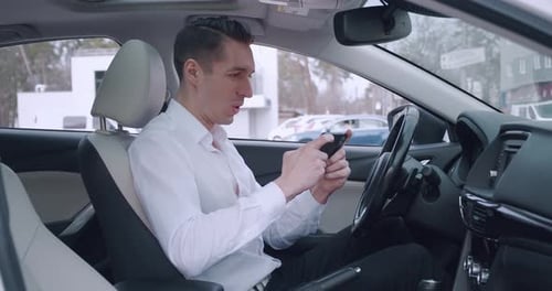 Excited man using phone in car
