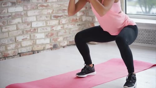 Strong Woman's Legs Squating in the Gym