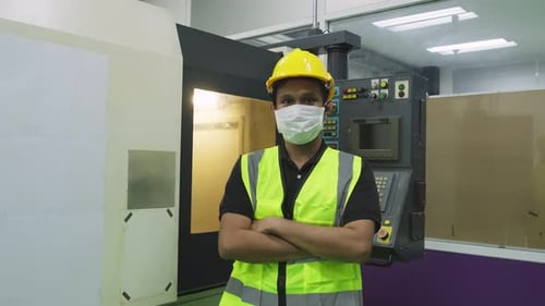 Factory Worker Standing in Front of Machinery