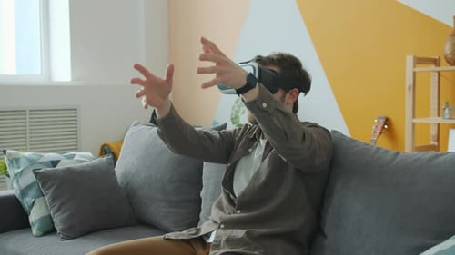 Young Man Experiencing Virtual Reality on Couch