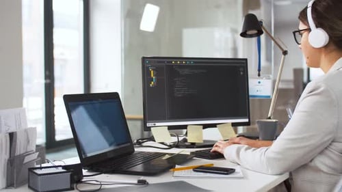 Woman Typing Code at Computer Desk in Office