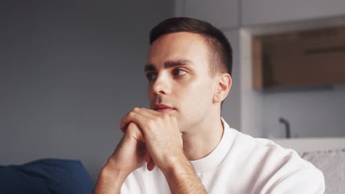 Close Up Upset Caucasian Man Sit Alone on Sofa at Home, Depressed Feeling Lonely Worried Sad