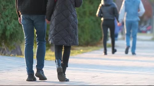 Back View of Young Couple Walking on City Street Enjoying Time Together