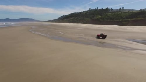 Aerial shot of 4x4 off road vehicle driving on beach