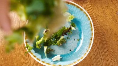 Fresh Green Salad Poured Into a Rustic Blue Bowl