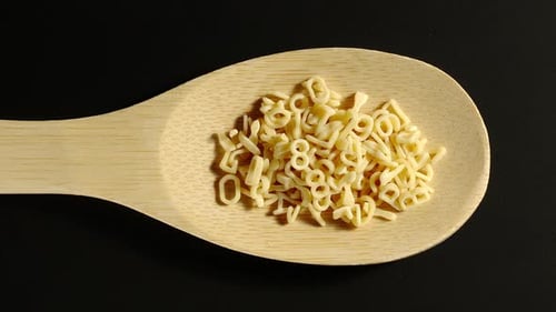 Alphabet Pasta Filling Wooden Spoon on Black