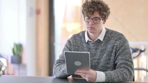 Young Adult Using Tablet at Desk Indoors
