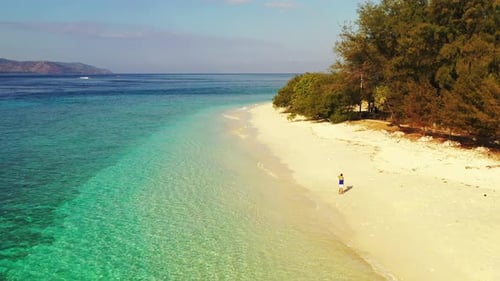 Tourist Standing On The Shore Capturing The Beautiful Scenery Of Lush Island And Crystal Clear Ocean