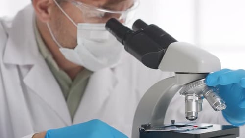Scientist Using Microscope in Bright Modern Laboratory